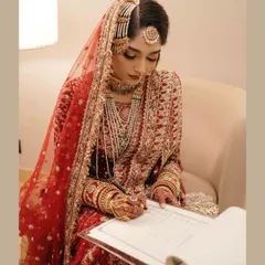 The bride signing the Nikaahnama, the official marriage contract. This is a pivotal and empowering moment, and we capture it with the grace and importance it deserves.