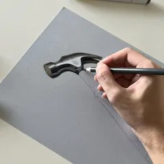 A close-up of the hammer drawing in progress. You can see how I use a black color pencil to define the contours and add depth to the handle before adding the final highlights.
