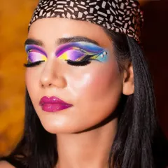 This shot captures the full impact of the colorful eye makeup against a warm background. I teach students about color theory to create harmonious and striking combinations.