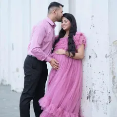 A tender moment between parents-to-be. This soft pink ruffled maternity gown is perfect for capturing the sweet anticipation of your little one's arrival.