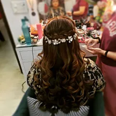 A beautiful half-up style for a party, featuring a braided crown and voluminous curls. I used a floral and pearl hair vine to add a touch of bridal elegance.