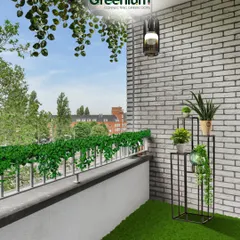 The "after" shot of a balcony transformation. The combination of artificial grass, a stylish plant stand, and hanging greenery against the white brick wall creates a fresh and inviting atmosphere.