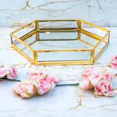 For a unique and contemporary look, we offer this hexagonal mirrored tray with a gold-finish frame. It serves as a stunning base for presenting gifts and doubles as a chic decor item for the home.