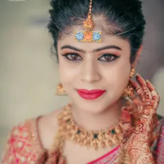 A striking close-up portrait of a bride, highlighting her beautiful makeup and traditional jewelry.