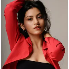 A bold and energetic studio shot. The combination of the red blazer, white jeans, and dynamic pose creates a high-impact image that is perfect for a fashion-forward portfolio.