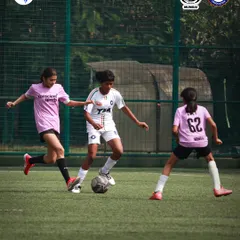Our girls' team in action, demonstrating skillful dribbling and teamwork. We are dedicated to providing equal opportunities for all aspiring footballers.