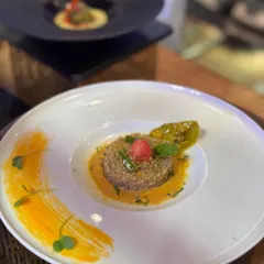 A modern take on a classic, this quinoa preparation is plated with an artistic swipe of mango puree and topped with fresh mint, creating a dish that is as beautiful as it is delicious.