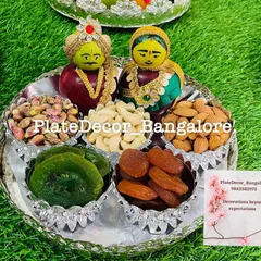 A close-up of one of my wedding platters, featuring traditional Marapachi Bommai figurines made from apples. The platter is filled with high-quality dry fruits like pistachios, cashews, and almonds, all arranged in an ornate silver tray.