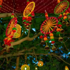 Colorful and traditional hanging decor, featuring thread-work wheels, pompoms, and bells, added a festive and folksy charm to this outdoor event.