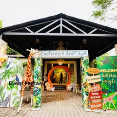 A grand welcome to "Eshaan's Jungle Land." The entrance is framed by vibrant, jungle-themed panels, a life-sized giraffe prop, and a custom welcome sign, setting an adventurous tone from the moment guests arrive.