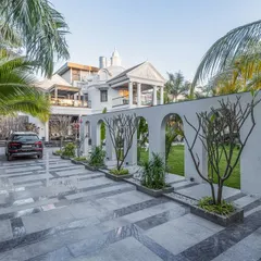 The dramatic arched wall not only defines the driveway but also frames beautiful vignettes of the garden, creating an experience of discovery with every step.