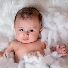 Welcome to the world, little one, resting on a cloud of dreams. This classic newborn setup is all about innocence and wonder.