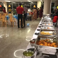 Guests mingling at a lively birthday party. Our buffet line is filled with a variety of dishes, ensuring there's something delicious for every guest to enjoy.