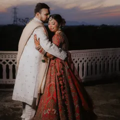 A tender embrace as the sun sets over Jaipur. This candid shot focuses on the quiet connection between the couple, with the beautiful twilight sky adding a touch of natural drama to their royal portrait.