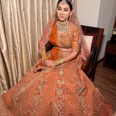 Our lovely client chose this traditional orange lehenga with detailed silver and gold threadwork for her wedding day. Her complete look is a perfect example of classic bridal elegance.