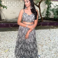 A client in a sophisticated grey and silver handwork Indo-Western lehenga. The modern print and embellished crop top create a chic and elegant look.