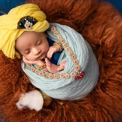 A close-up of the Little Krishna theme, focusing on the baby's peaceful face, the yellow turban, and the delicate jewelry. Every detail is carefully chosen to complete the vision.