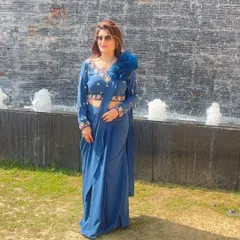 I love creating outfits that are both beautiful and practical. This pre-draped saree in a gorgeous shade of blue is exactly that. The blouse features intricate hand embroidery and a unique floral detail on the shoulder, giving you a sophisticated look without the hassle of draping.