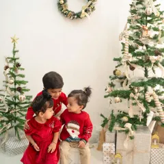 A sweet moment between three siblings during our Christmas mini-sessions. Dressed in festive red, their interaction is a perfect holiday memory.