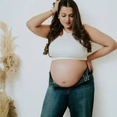 A confident and casual portrait of a mother-to-be in her favorite jeans. This shows that you can feel powerful and like yourself during your maternity shoot.