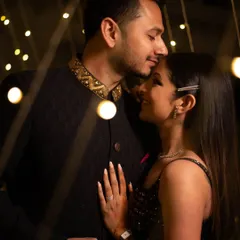 A tender forehead kiss amidst twinkling fairy lights. This is a classic pre-wedding shot that captures the warmth and intimacy of your relationship.