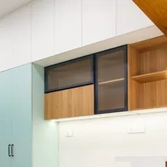 A detail shot of the upper cabinets, where I've mixed solid sage green, natural wood, and fluted glass to create visual interest and texture.