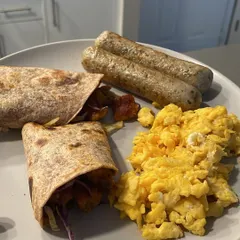 A perfect example of a power-packed breakfast to fuel your day. This plate has whole-wheat wraps, fluffy scrambled eggs, and chicken sausages, providing a great balance of protein, carbs, and fats to keep you full and energized.