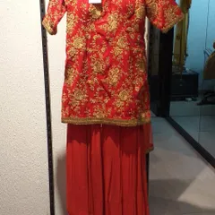 A classic red sharara suit with heavy gold embroidery on the short kurta. This traditional and vibrant outfit is perfect for celebrating festivals or attending a wedding.