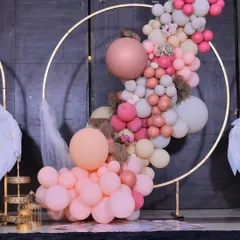 Detail of the organic balloon garland on a golden hoop, featuring a mix of matte and chrome balloons with pampas grass accents.