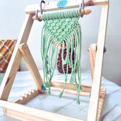 Here is a closer look at my portable macramé stand in action. The adjustable angle and built-in shook holder make it so easy to work on smaller projects like this green wall hanging. It is perfect for crafting on the go.