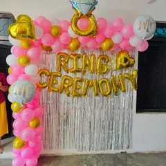 A bright and happy setup for a ring ceremony at home. I used a pink, white, and gold balloon arch against a silver tinsel curtain, with foil balloons to announce the special occasion.