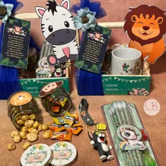 A closer look at the fun treasures inside our jungle-themed return gift hampers. We included a charming mug, tasty foxnuts, candies, playful pencils, and adorable keychains, perfect for thanking little guests.