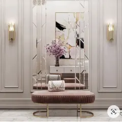 A luxurious entryway setup with a plush velvet bench, a large decorative mirror, and stylish wall sconces.