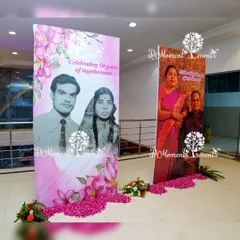 A heartfelt "then and now" photo display celebrating 50 years of togetherness. Large vertical banners showcase photos of the couple from their wedding day and the present, creating a beautiful tribute to their journey.
