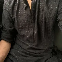A close-up of a black chikankari kurta. The intricate, self-colored threadwork and sequins add a touch of subtle elegance, perfect for an evening event.