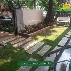 A wide view of the Indiranagar front yard project, showing the stone pathway, fresh lawn, and a bench nestled under a mature tree.