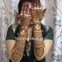 This design showcases the couple's initials 'S' and 'M' prominently on the back of the hands, surrounded by heart shapes and traditional patterns.