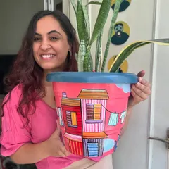 A finished city-themed planter, painted in bright pinks and reds. These make a wonderful, vibrant home for your favorite indoor plants.