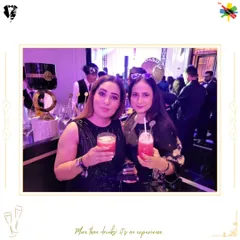 Two guests enjoying their vibrant pink cocktails at an elegant event. Our drinks are crafted to be a perfect accessory for a great night out.