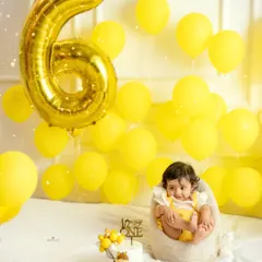 Another adorable shot from the half-birthday celebration, with the baby sitting up happily next to her cake.