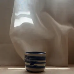 The Blue Fish Tumbler, captured in a stream of sunlight. This marble clay piece with its Japanese-inspired fish design is perfect for bringing a touch of elegance to your favorite beverage.