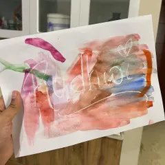 This little bubba is so excited to see his name appear as he paints over the wax-resist drawing. It's a perfect activity for two-year-olds.