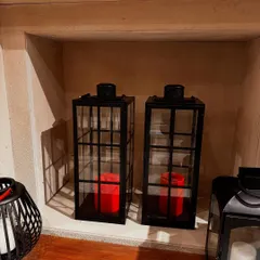 A cozy corner in my store featuring our black metal lanterns with red candles, perfect for creating a warm and inviting atmosphere.