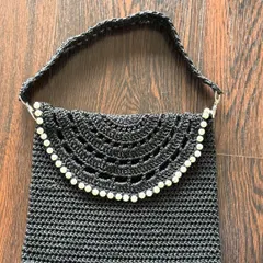 Another must-have for your collection, this black crochet bag features beautiful pearl detailing along the flap. The intricate openwork design makes it a versatile and elegant choice.