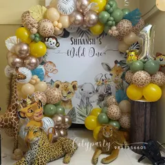 This 'Wild One' jungle safari theme is a popular choice for first birthdays. We included a custom backdrop with safari animals, an organic balloon arch with animal print balloons, and plush animal props like a leopard and lion to create an immersive experience.