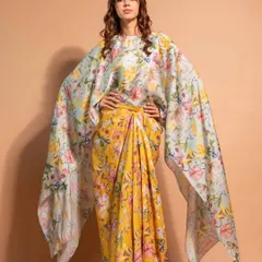 A full-length view of a beautiful floral cape outfit. The makeup is kept soft and natural to complement the vibrant, airy feel of the ensemble, with loose curls adding a touch of romance.