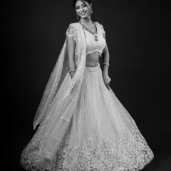 A black and white version of the full-length lehenga shot, creating a timeless and classic bridal portrait that focuses on the silhouette and intricate embroidery.