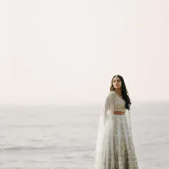 A serene portrait of the bride standing by the ocean. The vastness of the sea and sky creates a minimalist and powerful backdrop for this beautiful shot.