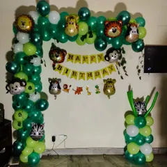 A simple yet fun jungle animal theme. The green balloon arch is decorated with multiple animal head foil balloons and a "Happy Birthday" banner.