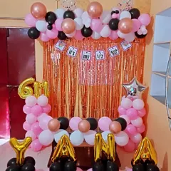 Another view of the half-birthday setup for "YANA". The decoration uses a color scheme of pink, black, white, and rose gold, with a banner that says "It's my 1/2 Birthday".